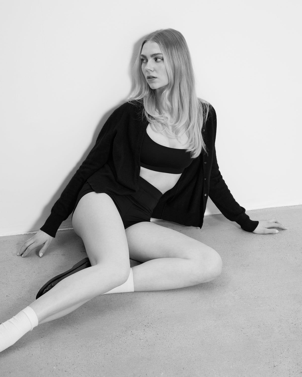 Woman sitting on the floor wearing a Baume Essentials TENCEL™ Lyocell bralette and shorts set, styled as sustainable everyday intimates with soft, breathable fabric in a minimalist studio.