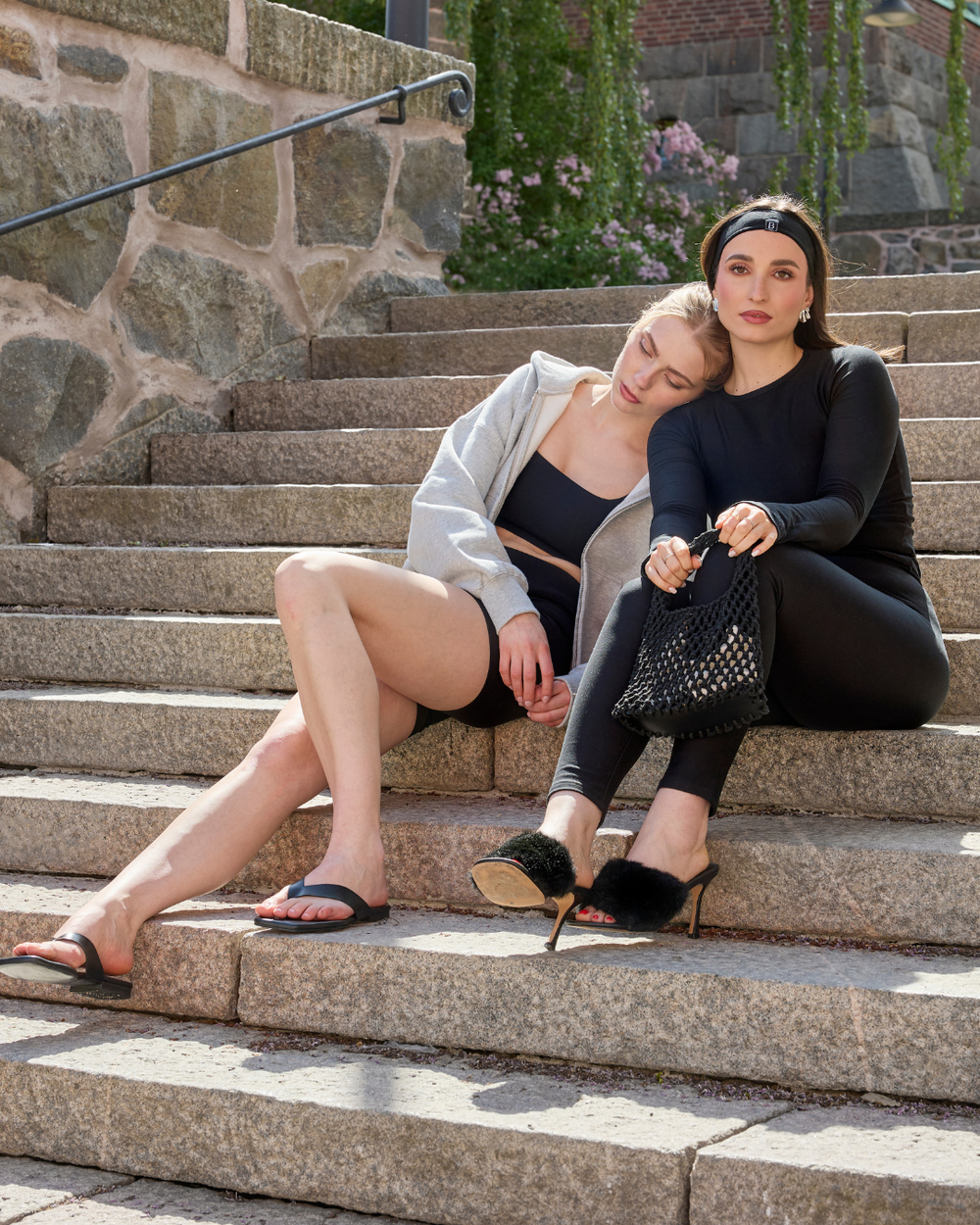 Two women wearing Baume Essentials TENCEL™ Lyocell everyday activewear sets in soft everyday loungewear outdoors.