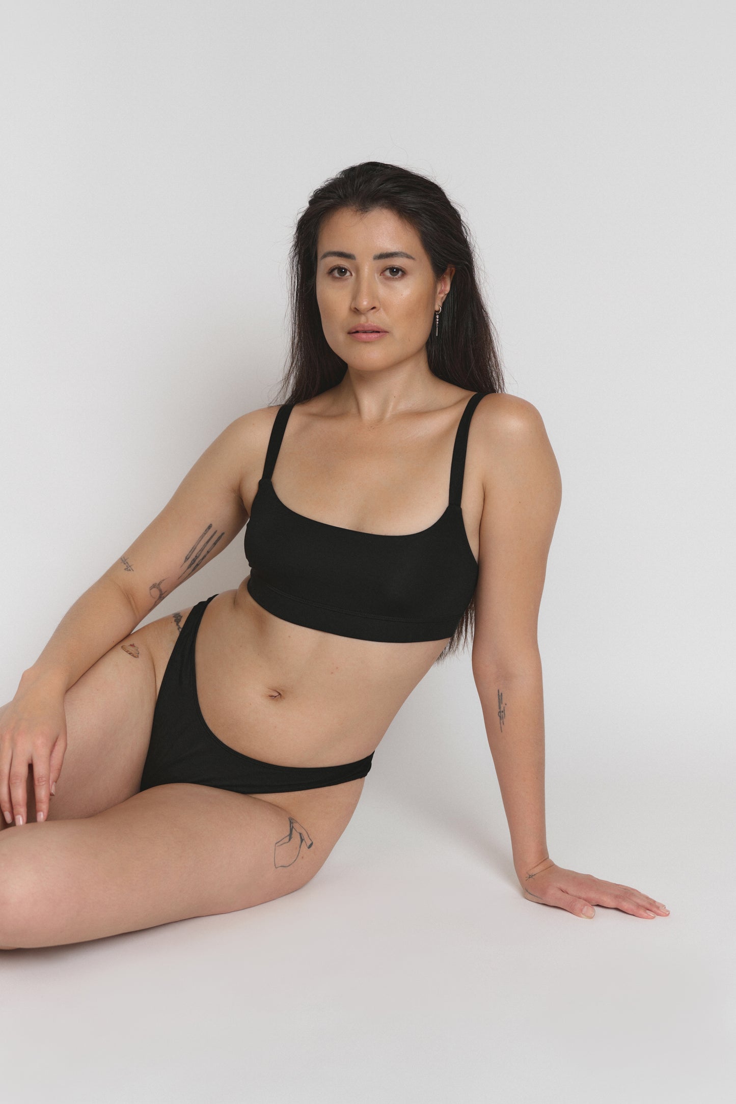 Model sitting wearing comfortable bralette, light support