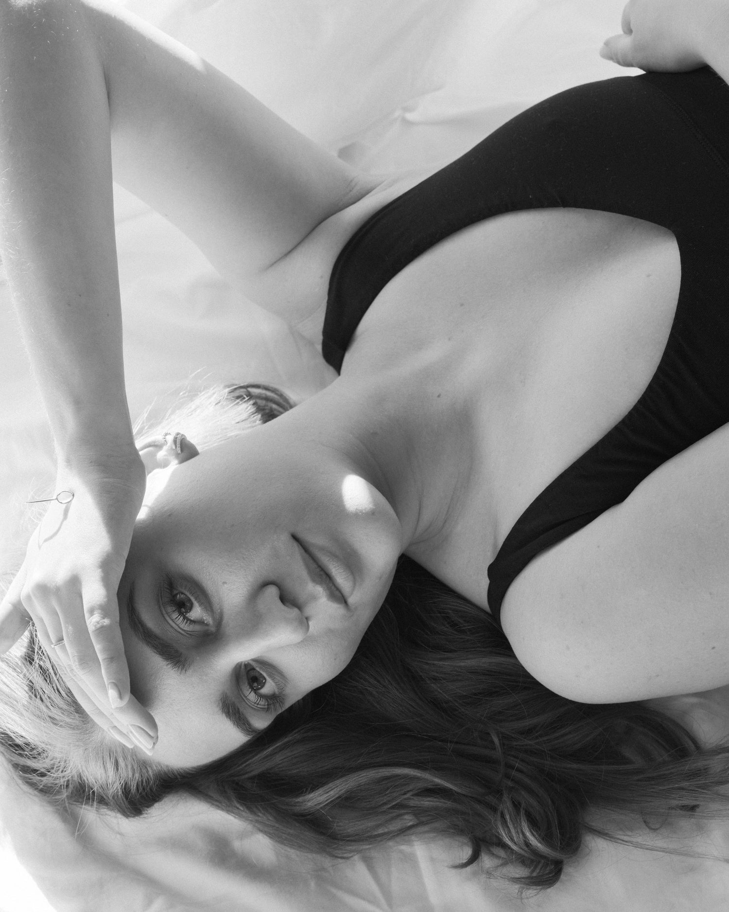 Sensual timeless deep v bralette closeup on woman laying in her sofa looking into the camera