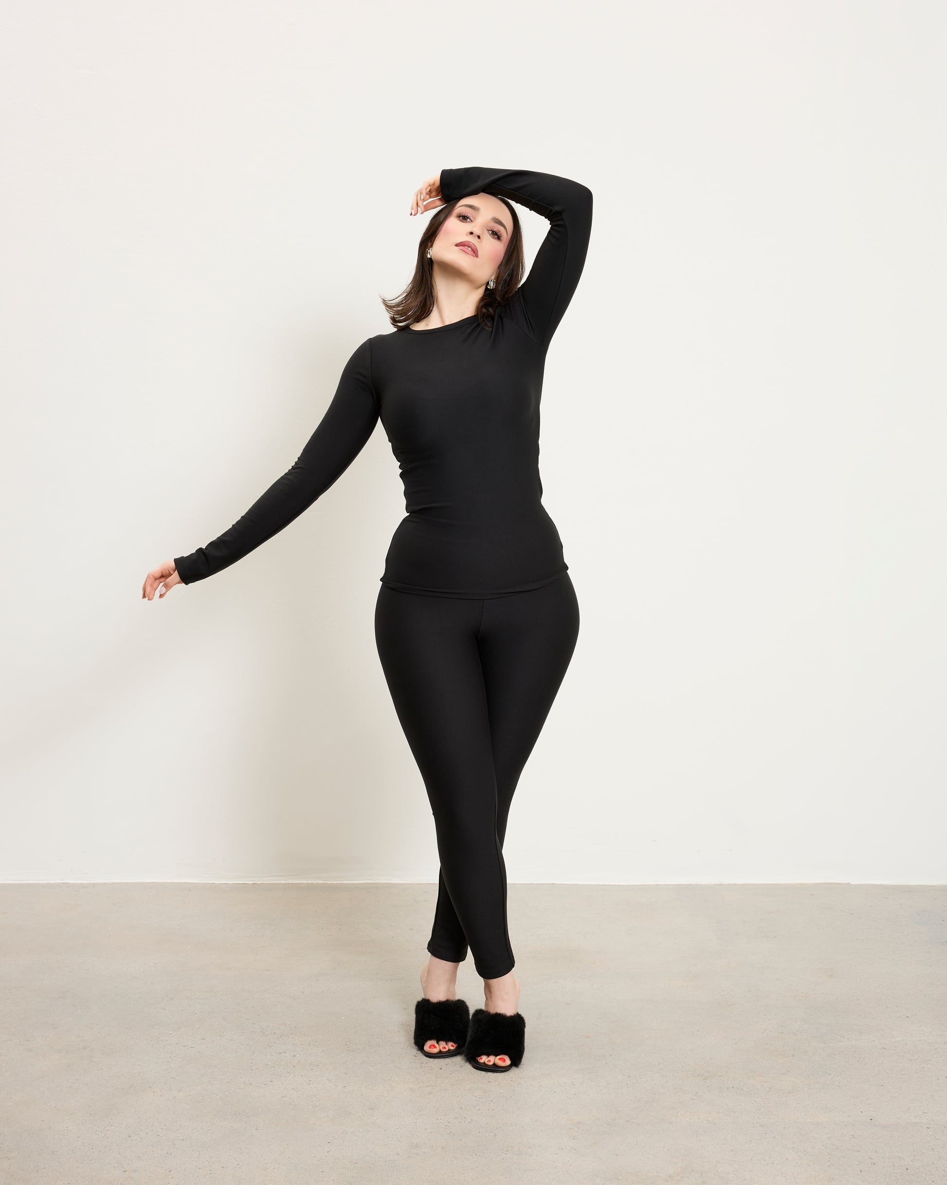 Model wearing Baume Essentials Atleisure long sleeve top and tights in TENCEL™ Lyocell designed for soft breathable everyday wear.