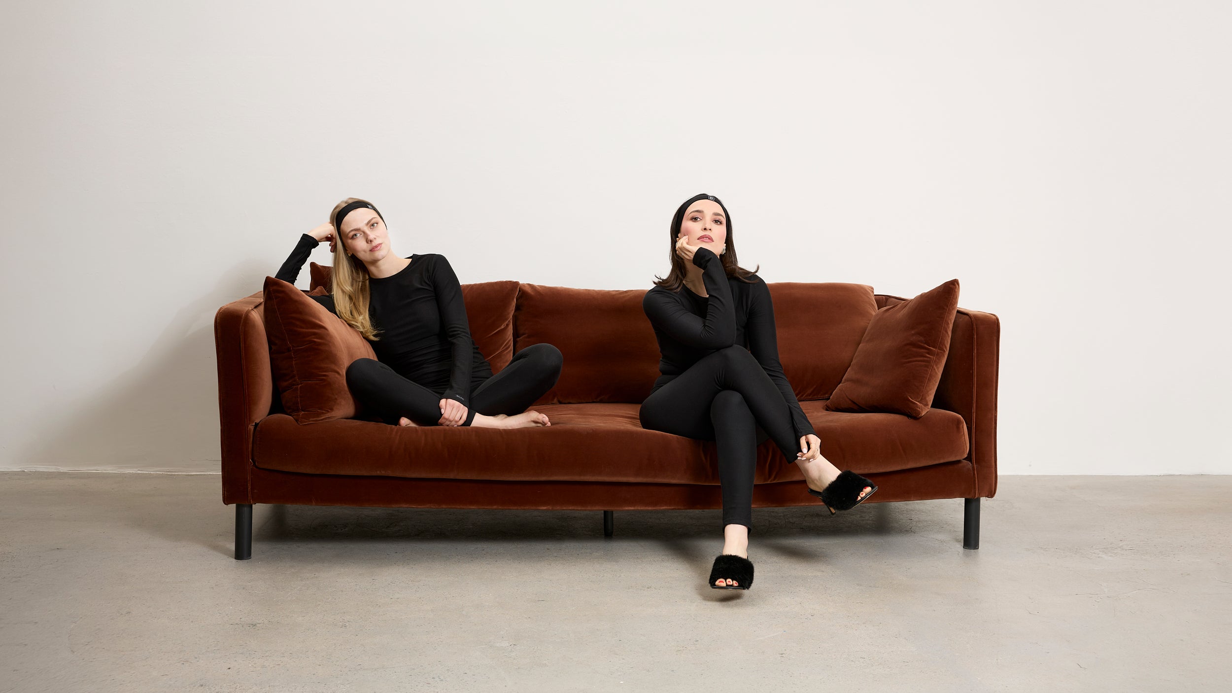 Two models wearing Baume Essentials Atleisure TENCEL™ Lyocell set in a relaxed studio lifestyle setting.
