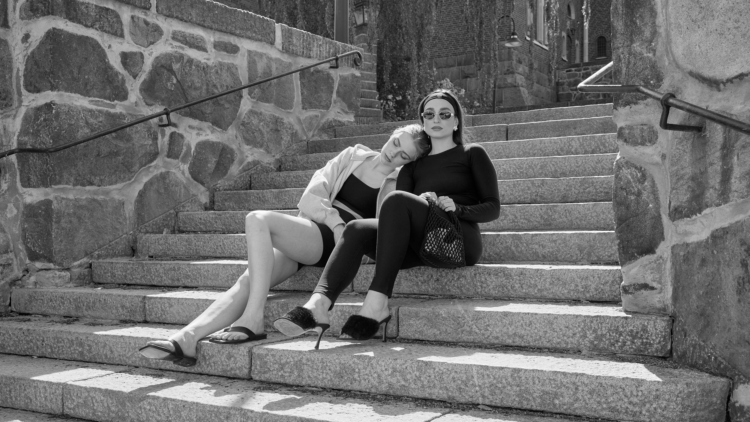 Two women wearing Baume Essentials TENCEL™ Lyocell everyday activewear sets in soft everyday loungewear outdoors.
