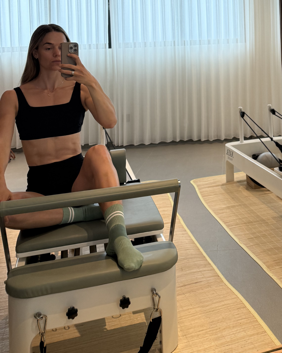 Woman wearing BAUME Essentials Form // Shorts and Form // Bralette in breathable TENCEL™ Lyocell during a reformer Pilates workout