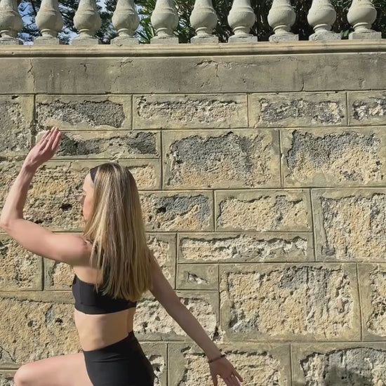 Woman exercising outdoors wearing the Baume Essentials Form Bralette and Form Shorts. Soft, breathable athleisure made from TENCEL™ Lyocell fibers with OEKO-TEX® certified materials. Comfortable everyday activewear designed for movement.